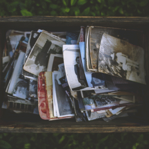 A box holding many black and white and older photos.